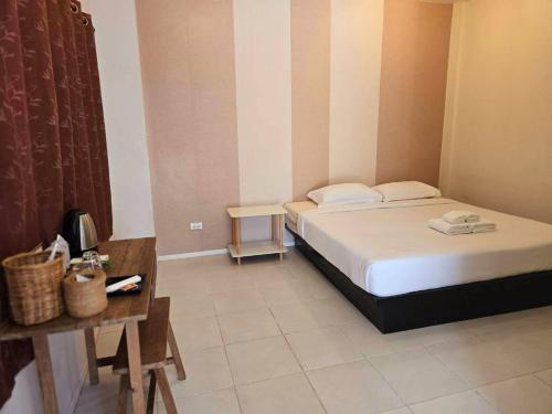a bedroom with a bed and a table with a telephone at แอทชฎา เชียงใหม่ @Shada Chiang Mai in Chom Thong