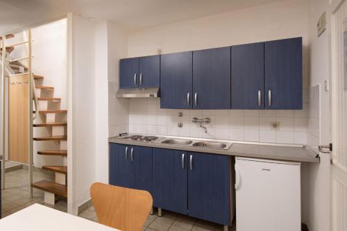 a kitchen with blue cabinets and a sink at Lanterna Resort in Tar