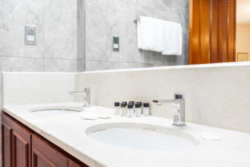 a bathroom with two sinks and a mirror at CARLTON COURT - MAYFAIR in London