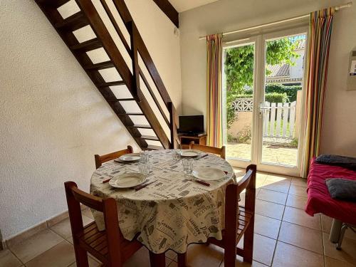 une salle à manger avec une table et des chaises et un escalier dans l'établissement Maison 2 pièces avec mezzanine, climatisée, proche plages, terrasse et parking – Argelès-sur-Mer - FR-1-225-106, à Argelès-sur-Mer
