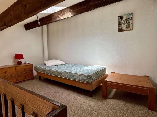une chambre avec un lit, une commode et une table dans l'établissement Maison 2 pièces avec mezzanine, climatisée, proche plages, terrasse et parking – Argelès-sur-Mer - FR-1-225-106, à Argelès-sur-Mer