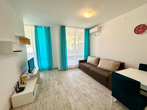 a living room with a couch and a television at Chateau Aheloy 2 - Menada Apartments in Aheloy