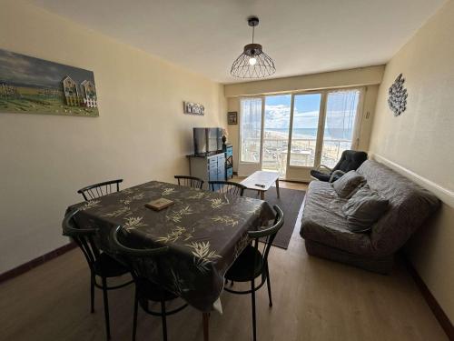 un salon avec une table et un canapé dans l'établissement Appartement face mer avec balcon, 50m plage, 5 couchages, parking, Saint-Jean-de-Monts - FR-1-224C-187, à Saint-Jean-de-Monts
