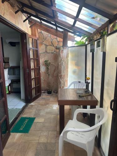 a room with a table and two white chairs at Shanti House Apart in Praia do Forte