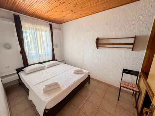 a bedroom with a bed and a window and a chair at House Private beach in Bibinje