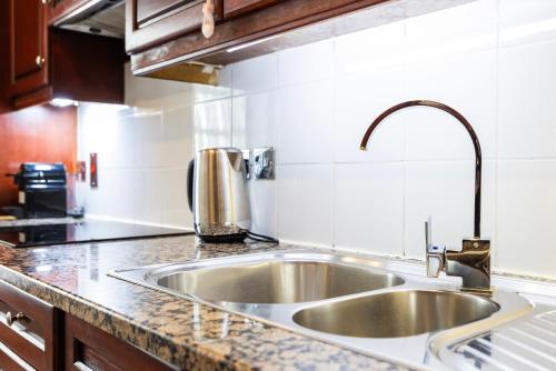 a kitchen counter with a sink in a kitchen at CARLTON COURT - MAYFAIR in London