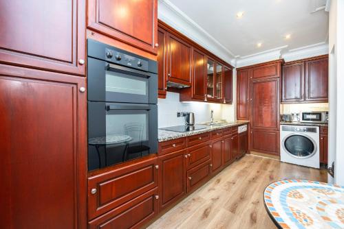 a kitchen with wooden cabinets and a stove top oven at CARLTON COURT - MAYFAIR in London