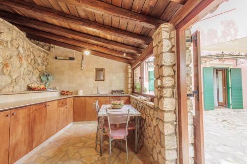 a kitchen with a table and a stone wall at Villa Oros in StrinÃ½las