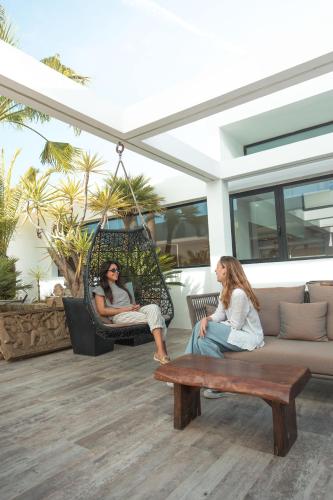 two women are sitting in a porch swing at Ibiza Corso Hotel & Spa in Ibiza Town