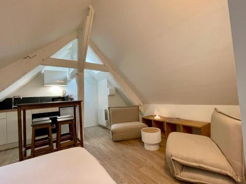 Cette chambre mansardée comprend un lit et un bureau. dans l'établissement Ker Latitude 3 vieux Dinan, à Dinan