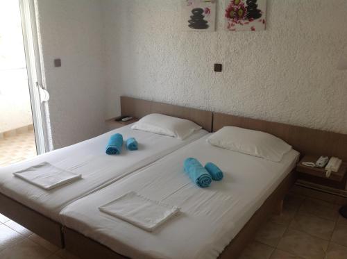 a bed with blue pillows and towels on it at Aialion studios & apartments - Steve Apartments in Rhodes Town