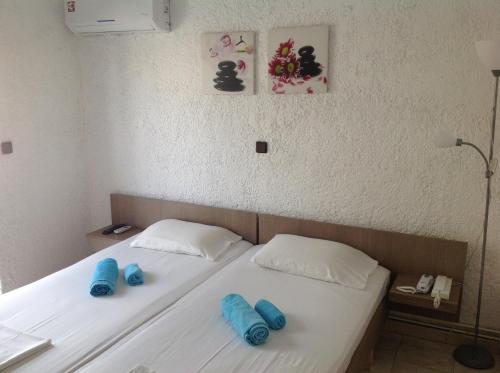 a bedroom with a bed with blue pillows on it at Aialion studios & apartments - Steve Apartments in Rhodes Town