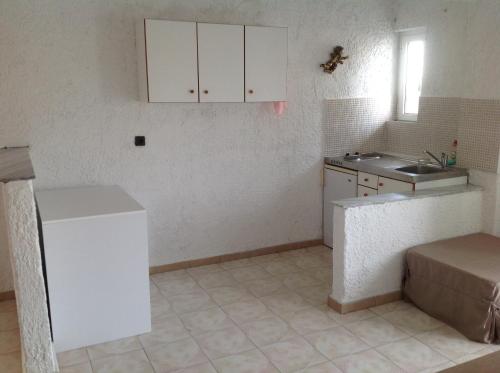 a kitchen with a white refrigerator and a sink at Aialion studios & apartments - Steve Apartments in Rhodes Town