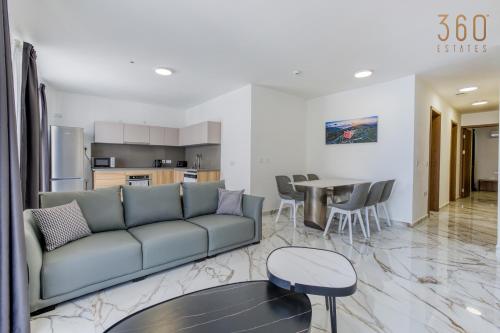 a living room with a couch and a table at The St Pauls Bay Escape Suites by 360 Estates in St Paul's Bay
