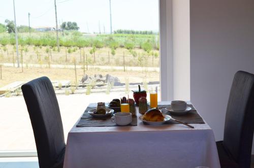 a table with a plate of food on it at Entre Vinhas & Mar in Óbidos
