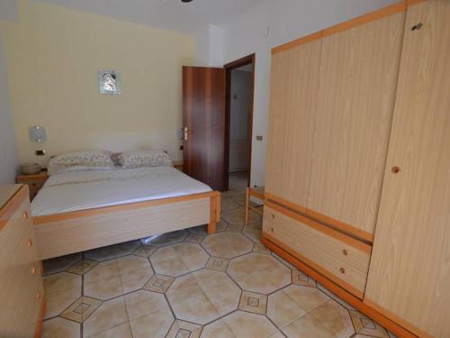 a bedroom with a bed and a wooden cabinet at Casa Vacanze Diamante - Parco del Sole in Diamante