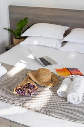 a hat and a purse and a laptop on a bed at Sani Gulf I & II in Sani Beach
