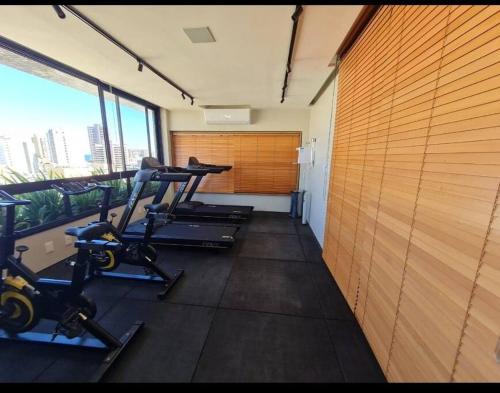 un gimnasio con 3 cintas de correr y una gran ventana en Quarto e Sala de Alto Padrão, en Salvador