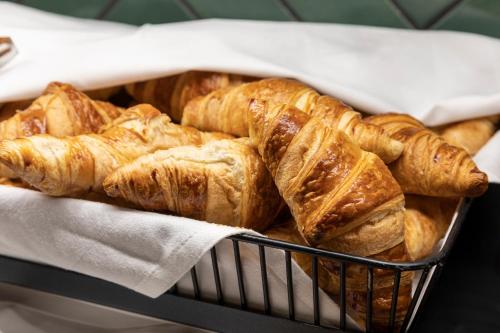 a basket full of croissants and other pastries at Original Sokos Hotel Vantaa in Vantaa