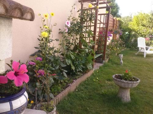 - un jardin avec des fleurs et une chaise dans la cour dans l'établissement entre ville et mer, à Lanester