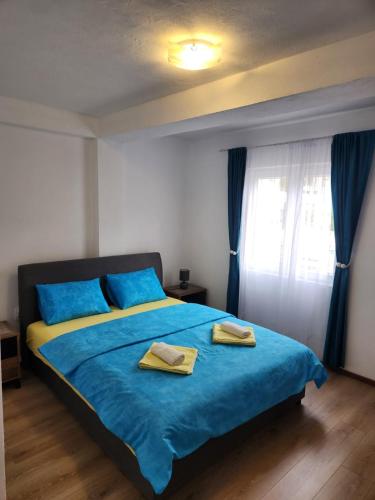 a bedroom with a blue bed with two towels on it at Apartment Tamara in Tivat