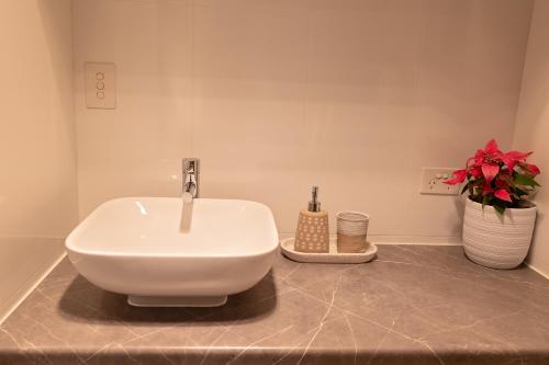 a bathroom with a sink and a vase with flowers at Casa Blu in Port Noarlunga South