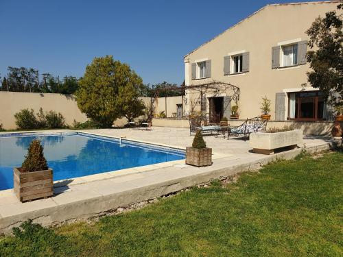 une maison avec une piscine devant une maison dans l'établissement La Bastide Des Oliviers, à Châteaurenard