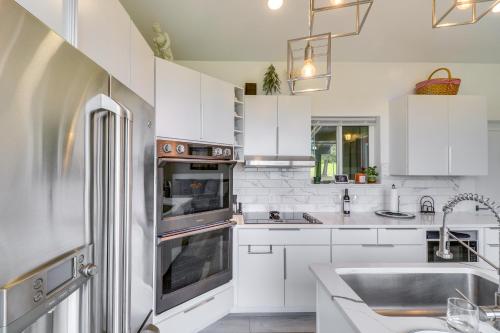 a kitchen with white cabinets and a stainless steel refrigerator at Hot Tub and Views Sunset Valley Retreat in Eureka in Eureka