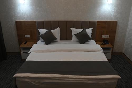 a bedroom with a large bed with white sheets and pillows at My Status Hotel in Tashkent