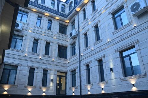 a large white building with lights on it at My Status Hotel in Tashkent