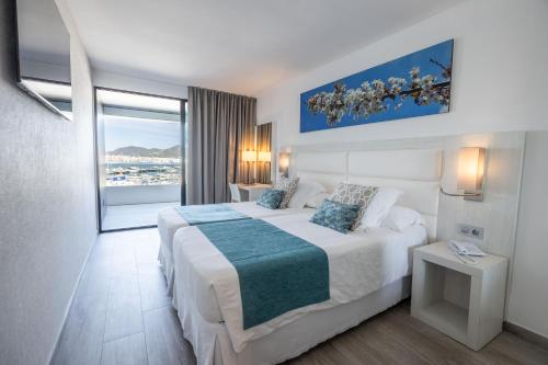 a hotel room with a bed and a large window at Ibiza Corso Hotel & Spa in Ibiza Town