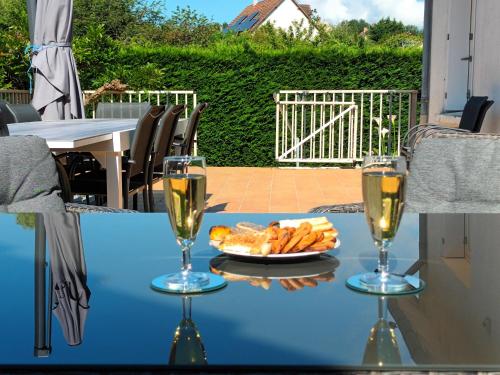 - une table avec deux verres de champagne et une assiette de pain dans l'établissement Au Nom des Dames, Maison et Table d'Hôtes, près de Chenonceau et du Zoo de Beauval, à Faverolles-sur-Cher
