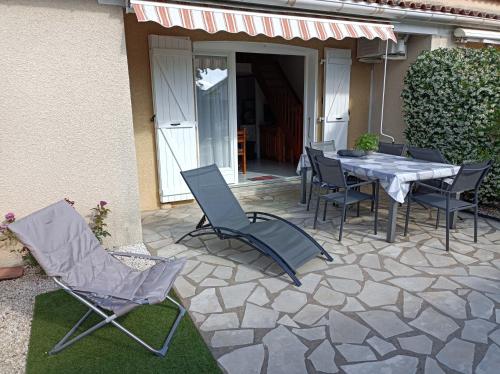une table et des chaises assises sur une terrasse dans l'établissement Villa 6 pers climatisee avec terrasse et Parking prive - V0270, à Vias