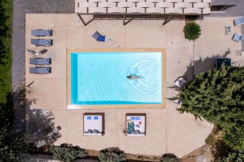 an overhead view of a large pool with a person swimming at Villa Ellie - heated pool, playground, garden & BBQ! in Vederoi