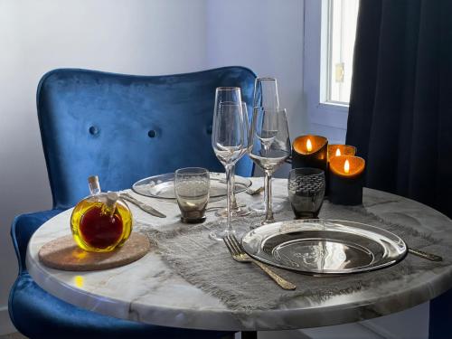 une table avec des assiettes et des verres sur une chaise bleue dans l'établissement Sauna & Détente - Suite Privée - Tours - Netflix, à Tours