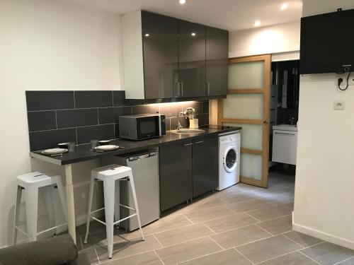 - une cuisine avec lave-linge et sèche-linge dans la chambre dans l'établissement Plein coeur de Paris, à Paris