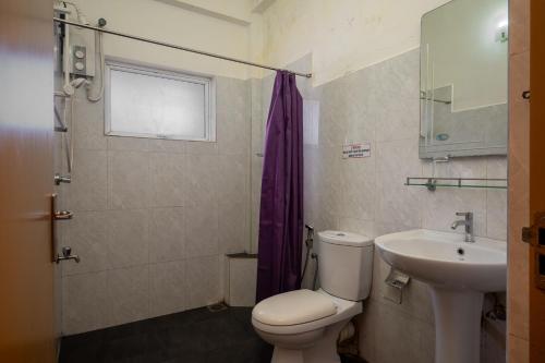a bathroom with a toilet and a sink at Hotel Oviya in Vavuniya