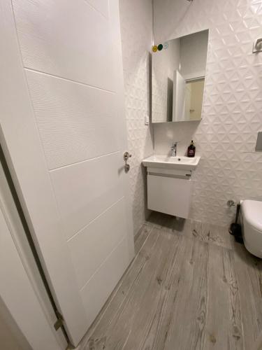 a white bathroom with a sink and a toilet at Sapphire Suites Taksim in Istanbul