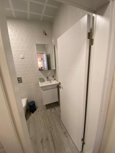 a white bathroom with a sink and a mirror at Sapphire Suites Taksim in Istanbul