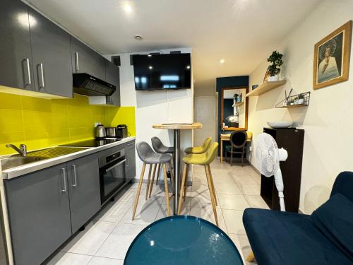 une cuisine avec une table et des chaises dans une pièce dans l'établissement La Loge d'Avignon - Cœur de Ville - Wifi, à Avignon