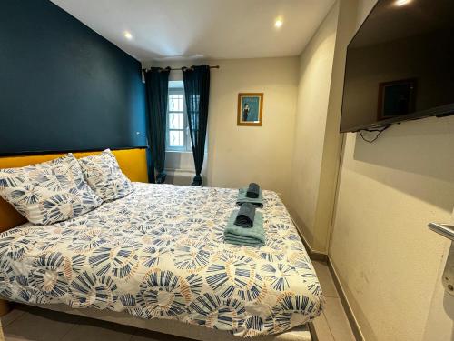 Cette petite chambre comprend un lit avec un mur bleu. dans l'établissement La Loge d'Avignon - Cœur de Ville - Wifi, à Avignon