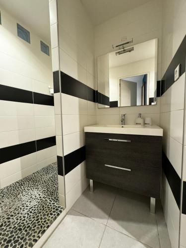 une salle de bain avec un lavabo et un miroir dans l'établissement La Loge d'Avignon - Cœur de Ville - Wifi, à Avignon