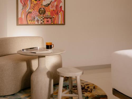 a table and a stool with a coffee cup on it at Hyde Ibiza in Cala Llonga