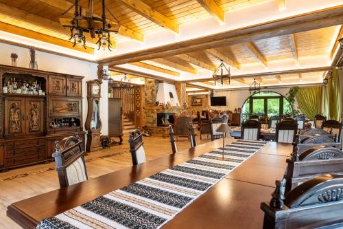 a large room with tables and chairs and a living room at Casa Baciu Colacu in Fundu Moldovei