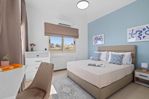 a bedroom with a bed and a desk and a window at Harmonia Luxury Villa by Nomads in Peyia
