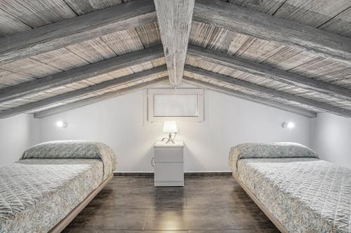Dos camas en una habitación con techos de madera. en Casa El Trebol, en Vejer de la Frontera