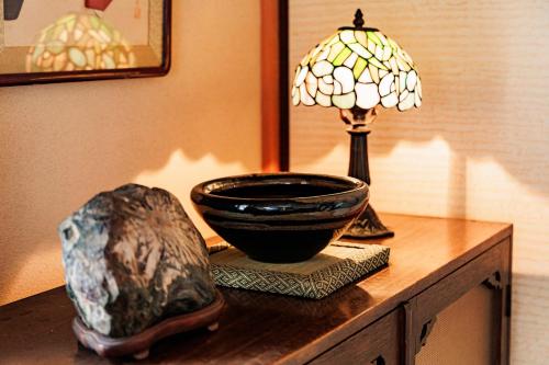 a table with a lamp and a bowl on it at 彦宿Hikojyuku戸建て貸切宿 in Hikone