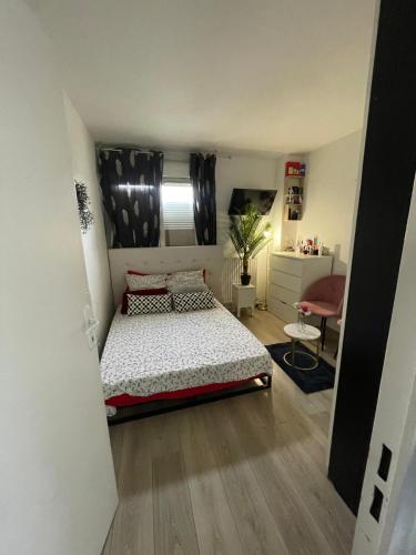 une chambre avec un lit et une chaise dedans dans l'établissement Appart confort T3, à Ivry-sur-Seine