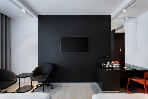 a living room with black walls and black chairs at Verdi Gzira Promenade in Sliema