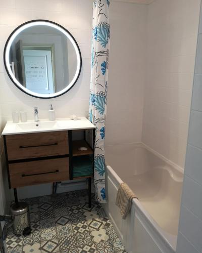 une salle de bain avec un lavabo, une baignoire et un miroir dans l'établissement Magnifique T2 standing piscine proche mer, à La Ciotat